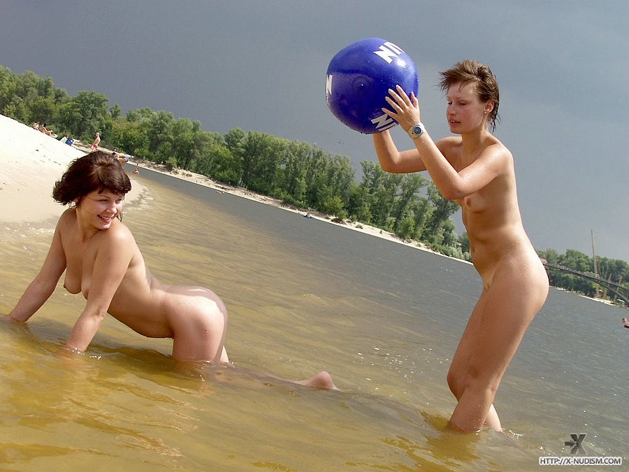 Sexy giovani nudi giocano insieme in una spiaggia pubblica
 #78610200