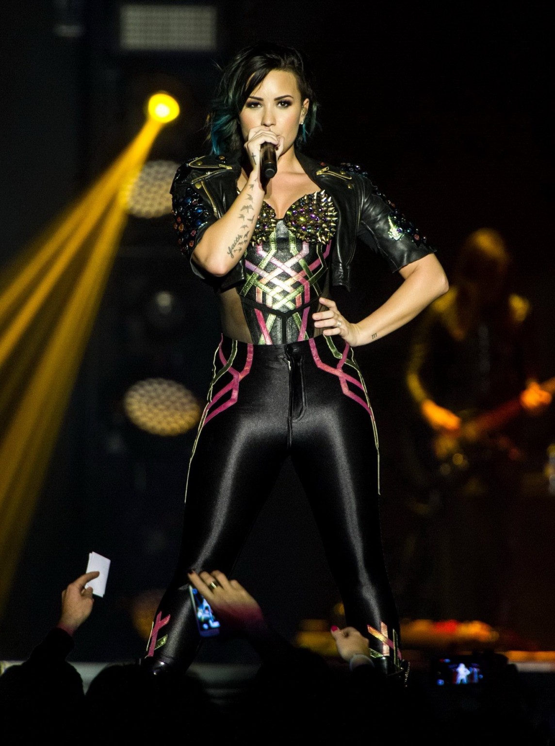 Demi Lovato wearing tights and spiky corset on stage in Birmingham