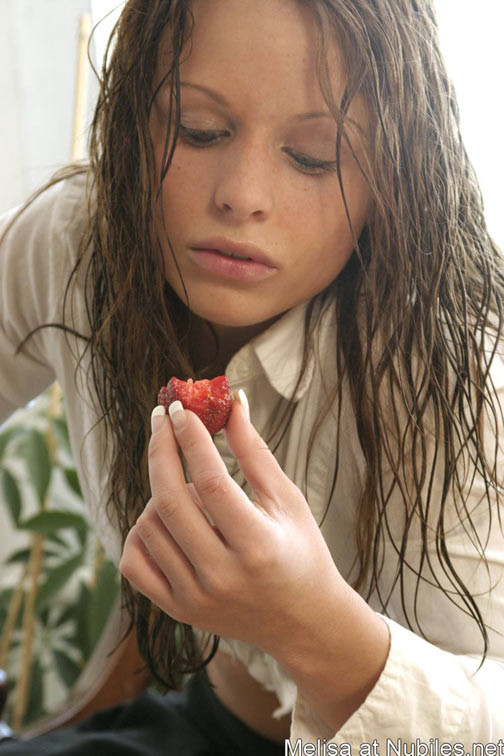 Regardez Melisa manger une fraise fraîche en suçant son jus sucré.
 #68370836
