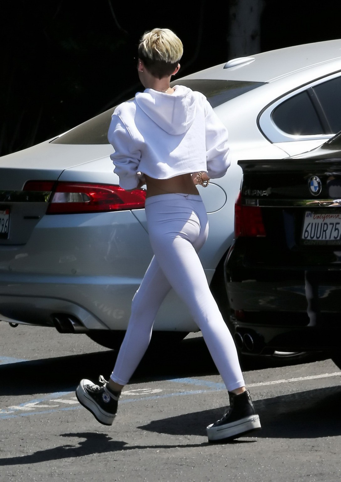 Miley Cyrus en collant blanc et débardeur essayant de se cacher des paparazzis ou de la police.
 #75229713