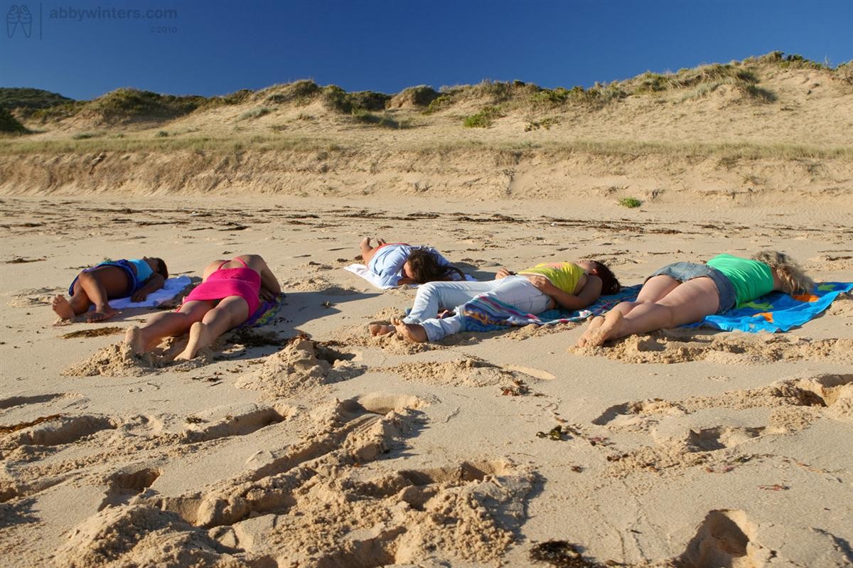 Cinco hermosas aficionadas australianas se desnudan en la playa al atardecer
 #72284061