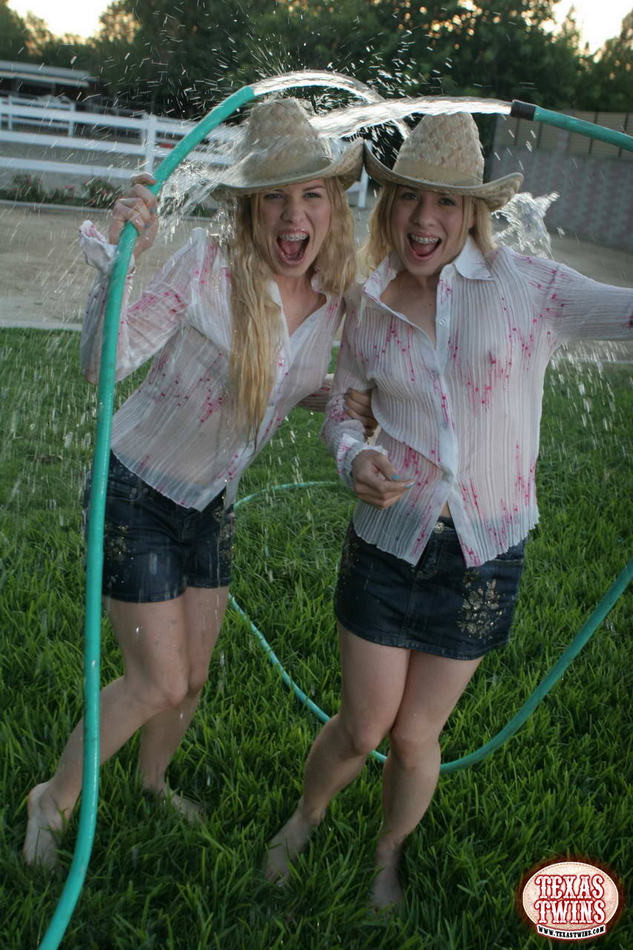 Twin eighteen year old sisters hosing each other off outdoors #78600976