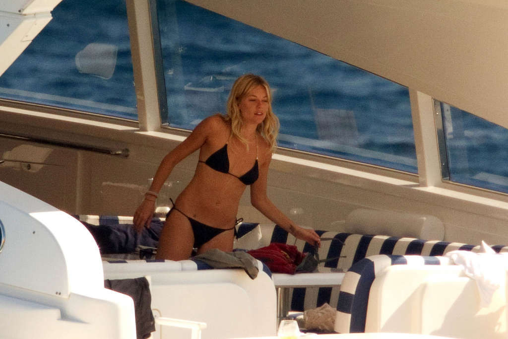 Sienna Miller che espone il suo corpo sexy e culo caldo in bikini nero su yacht
 #75338074