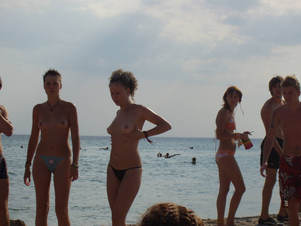 Nudista bionda si spoglia nuda in una spiaggia pubblica
 #72256735