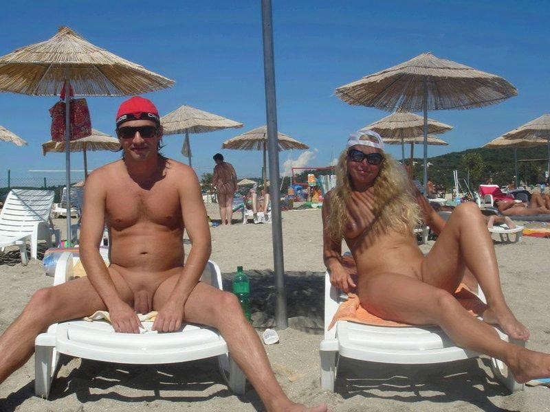 Nudista bionda si spoglia nuda in una spiaggia pubblica
 #72256755