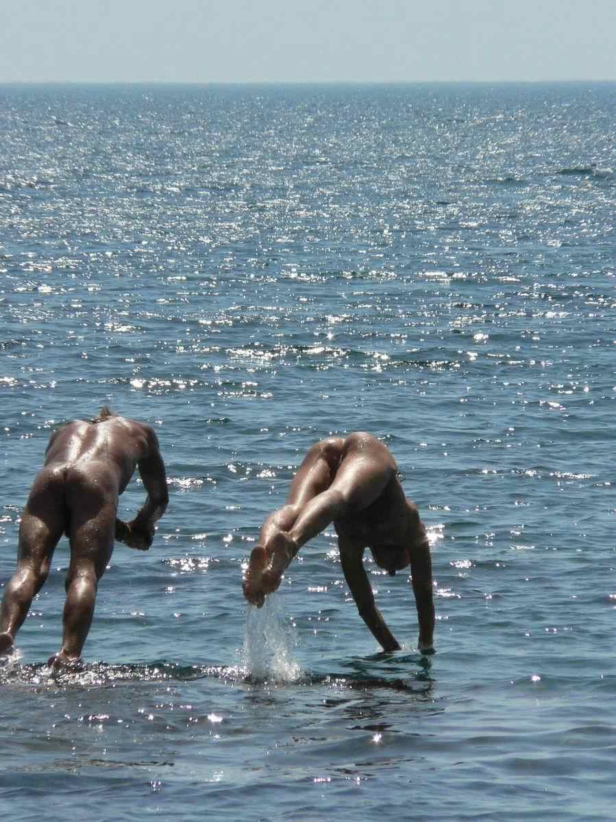 Des amies jeunes nues s'amusent sur une plage publique
 #72247483