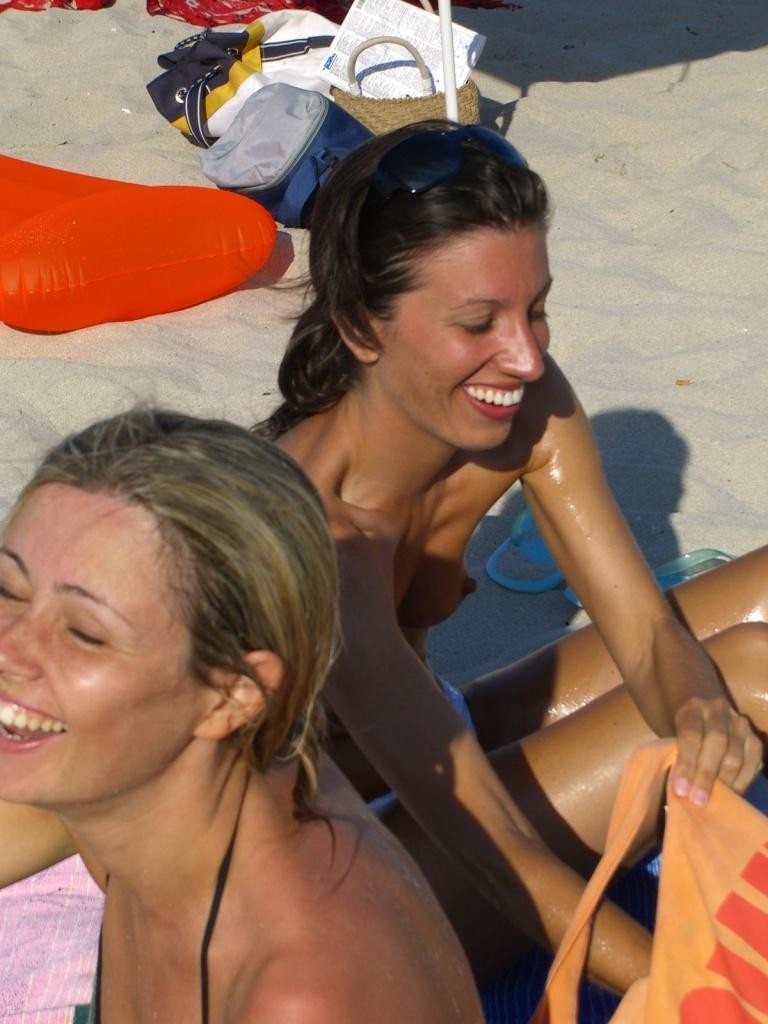 Guarda una ragazza nuda in spiaggia che abbronza il suo corpo caldo
 #72249315