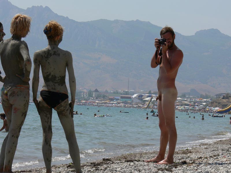 Une jeune femme sexy aux courbes harmonieuses se déshabille sur une plage nudiste.
 #72256778
