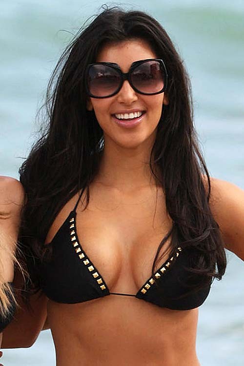 Kim Kardashian pose en bikini sur la plage et montre ses énormes seins.
 #75284564