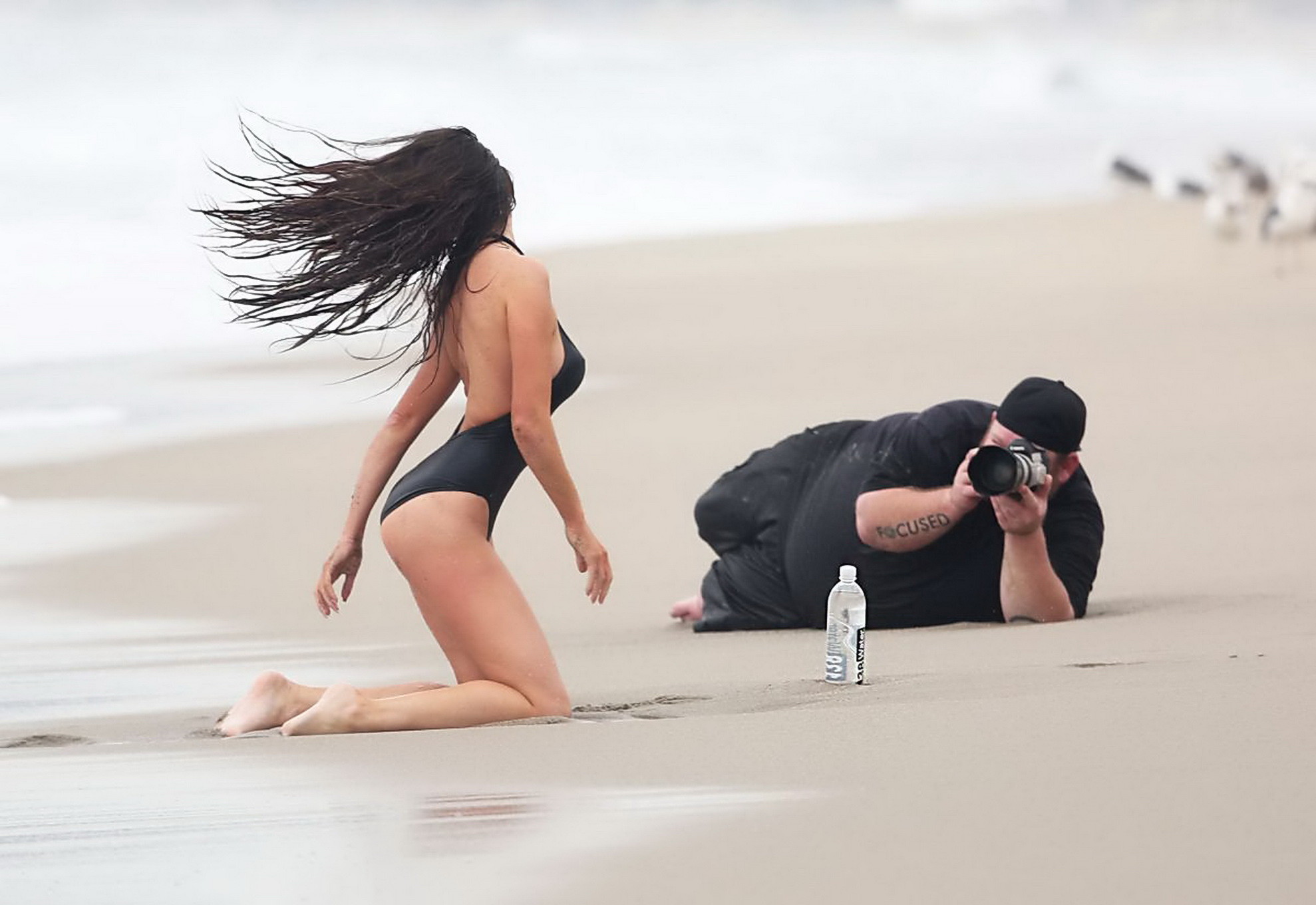 Kayla swift montre ses seins et ses fesses en maillot de bain noir alors qu'elle se gèle sur la plage.
 #75177282
