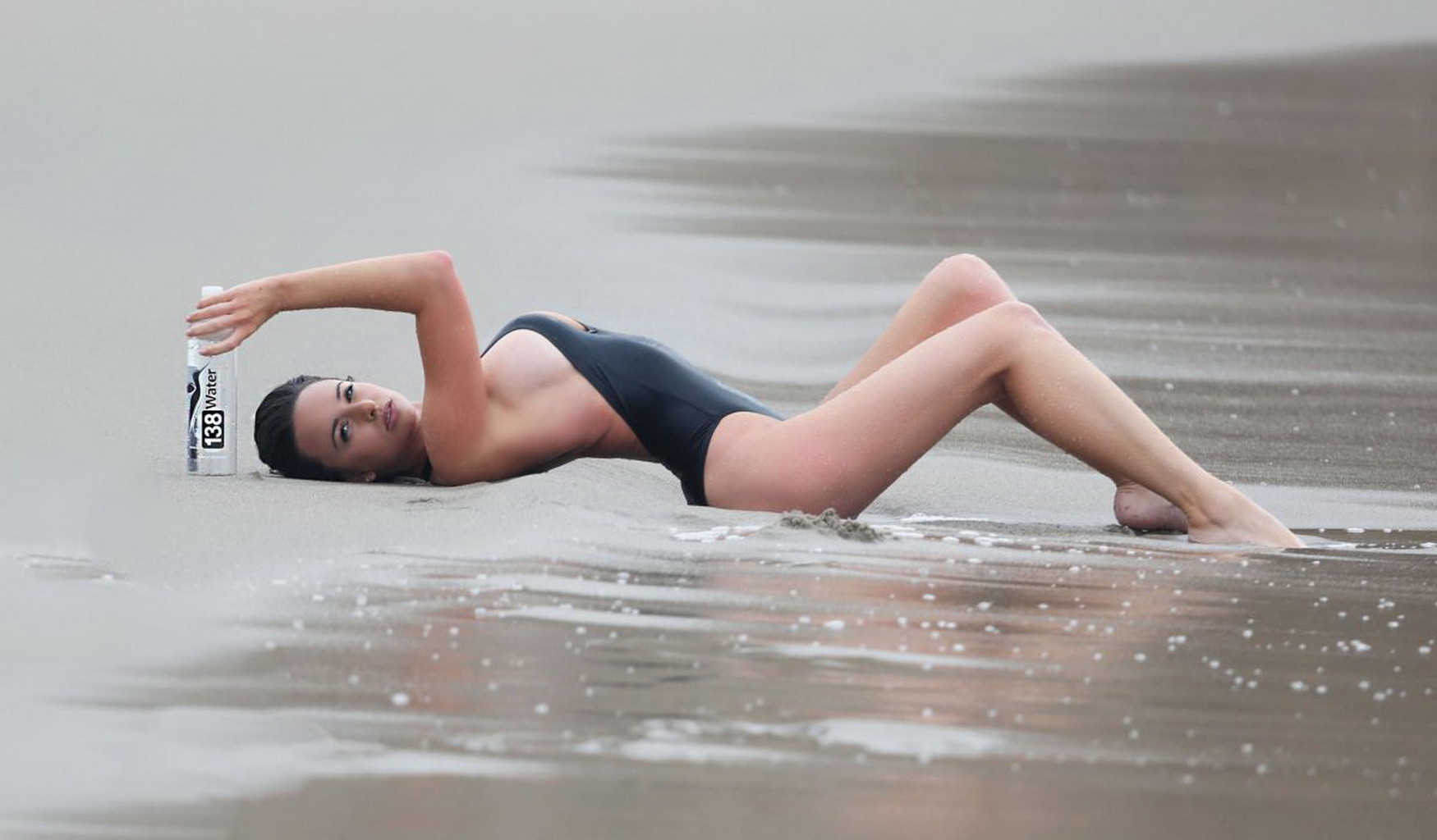 ケイラ・スウィフト、ビーチで凍えながら黒の水着で横乳とポッキーを見せる
 #75177350