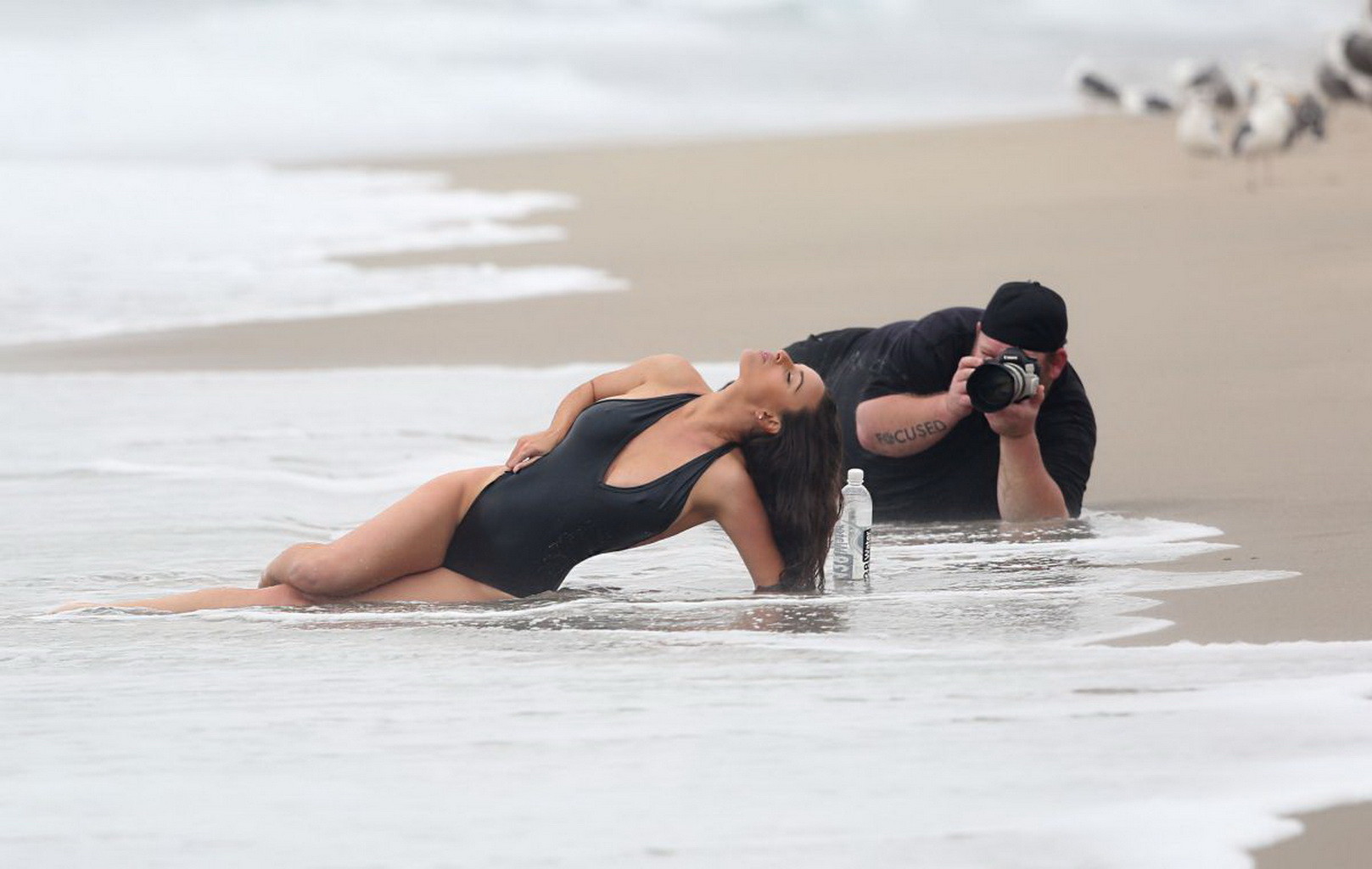 Kayla swift montre ses seins et ses fesses en maillot de bain noir alors qu'elle se gèle sur la plage.
 #75177377
