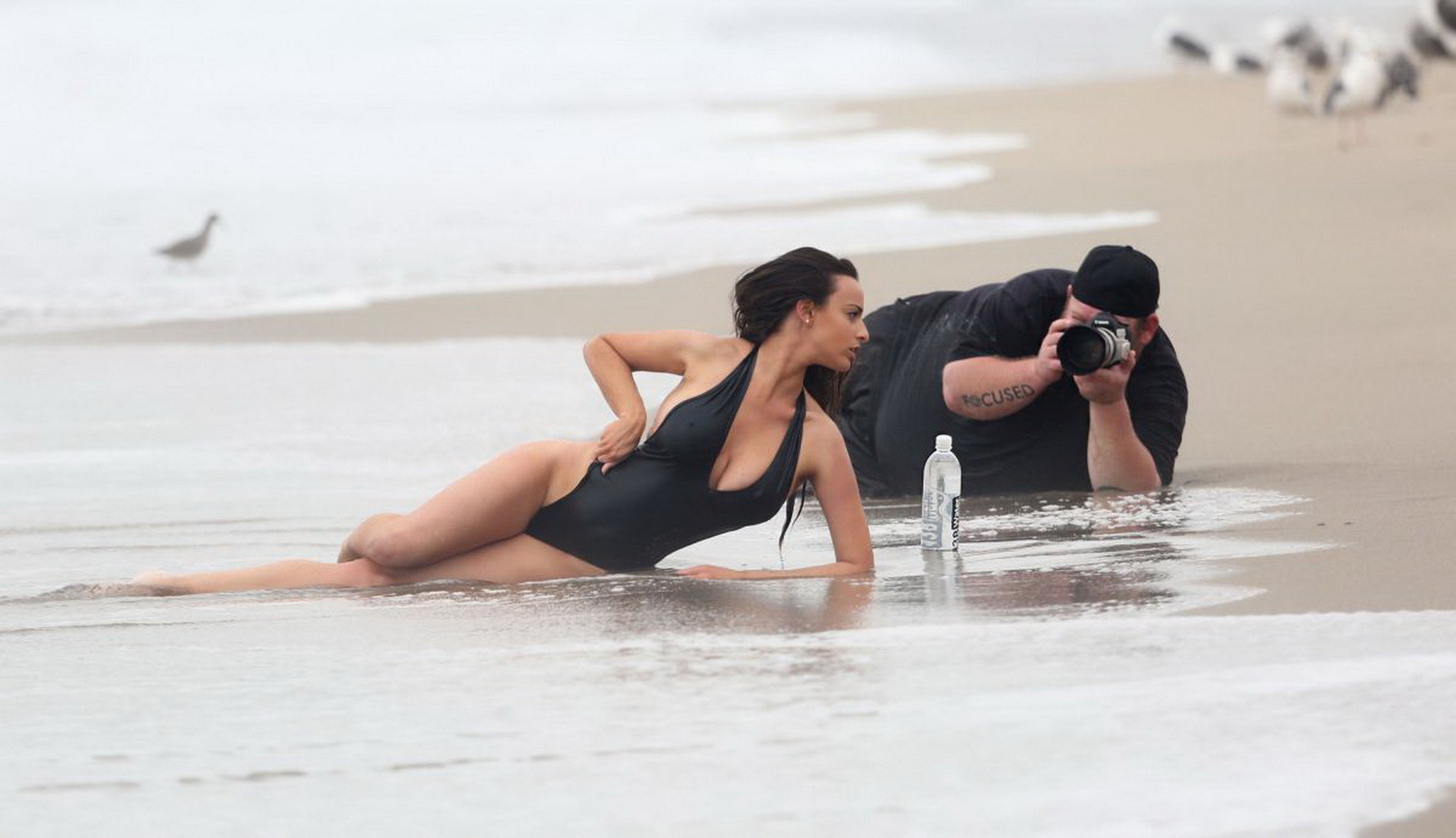 Kayla swift montre ses seins et ses fesses en maillot de bain noir alors qu'elle se gèle sur la plage.
 #75177388