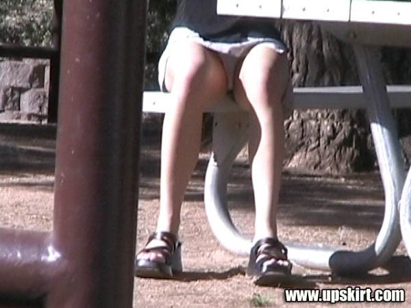 Subidas de falda bajo una mesa de picnic al aire libre en un parque
 #78637122