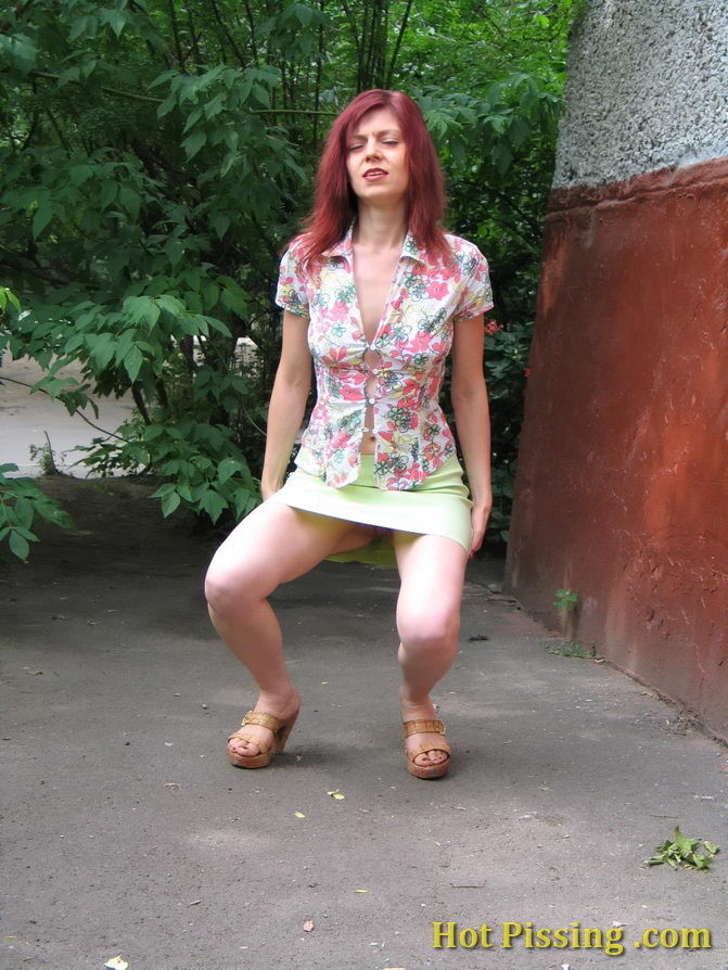 Hot redhead can not hold it in and relieves herself behind a building #76566114