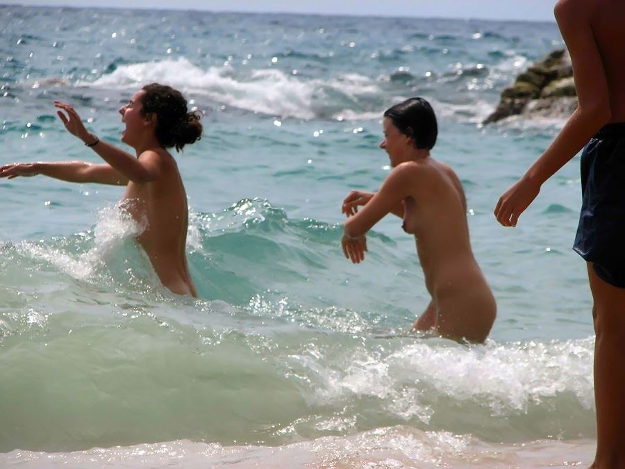 Des ados sexy et nus jouent ensemble sur une plage publique
 #72254929