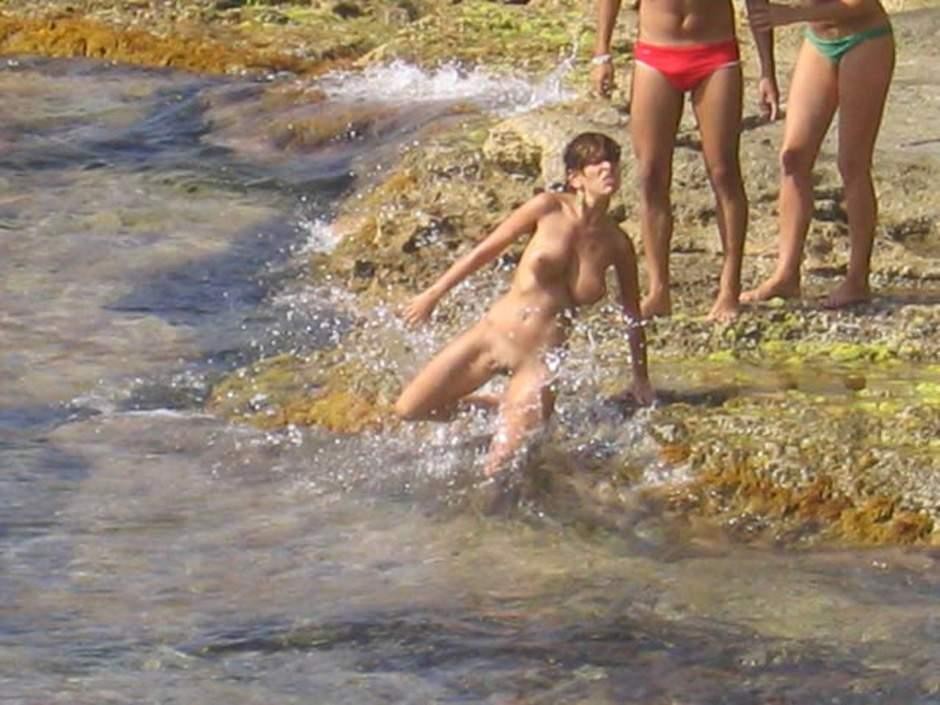 Mira a estas nudistas suaves jugar en una playa pública
 #72251773