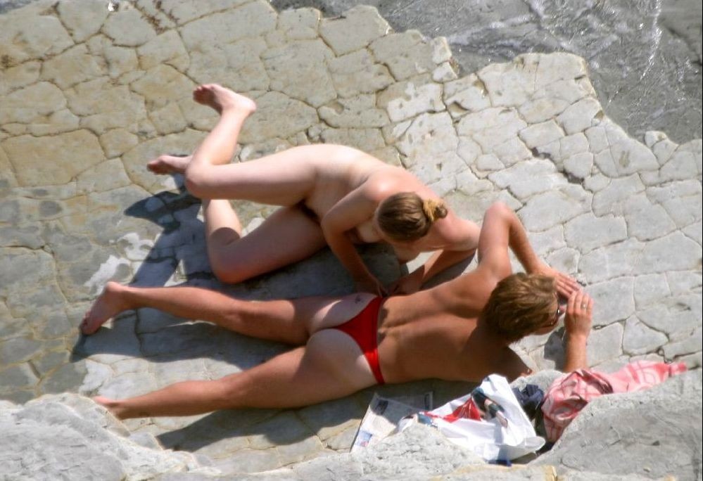 Une jeune femme aux gros seins n'hésite pas à poser nue sur la plage.
 #72254019