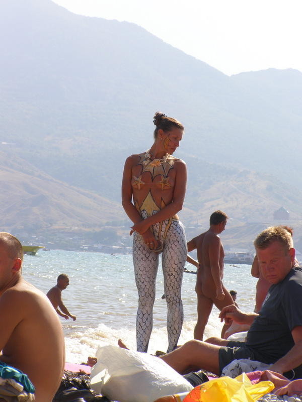 Une jeune nudiste n'hésite pas à poser nue sur la plage.
 #72256174