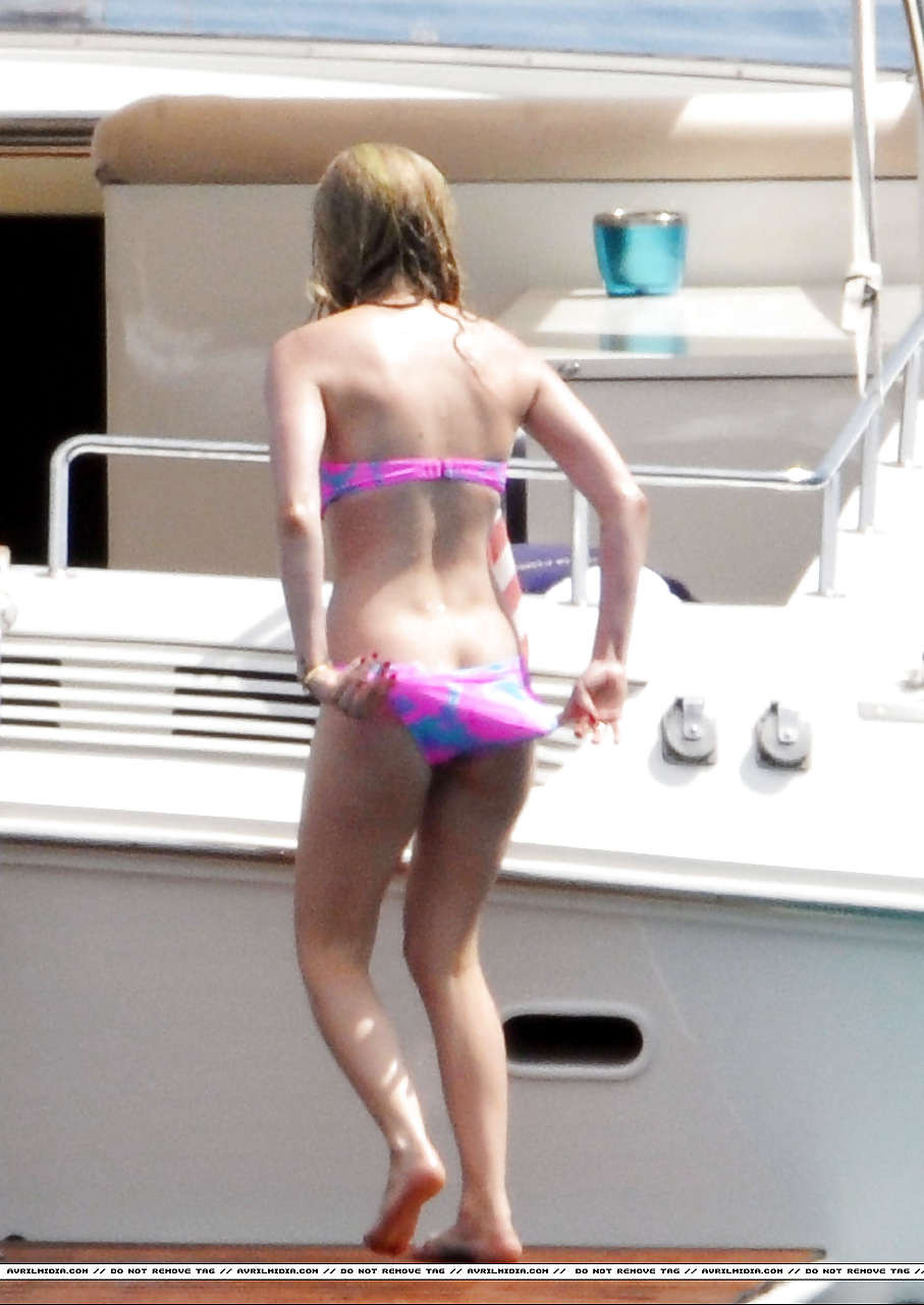 Avril Lavigne montrant une partie de son cul et son téton en bikini sur la plage.
 #75297386