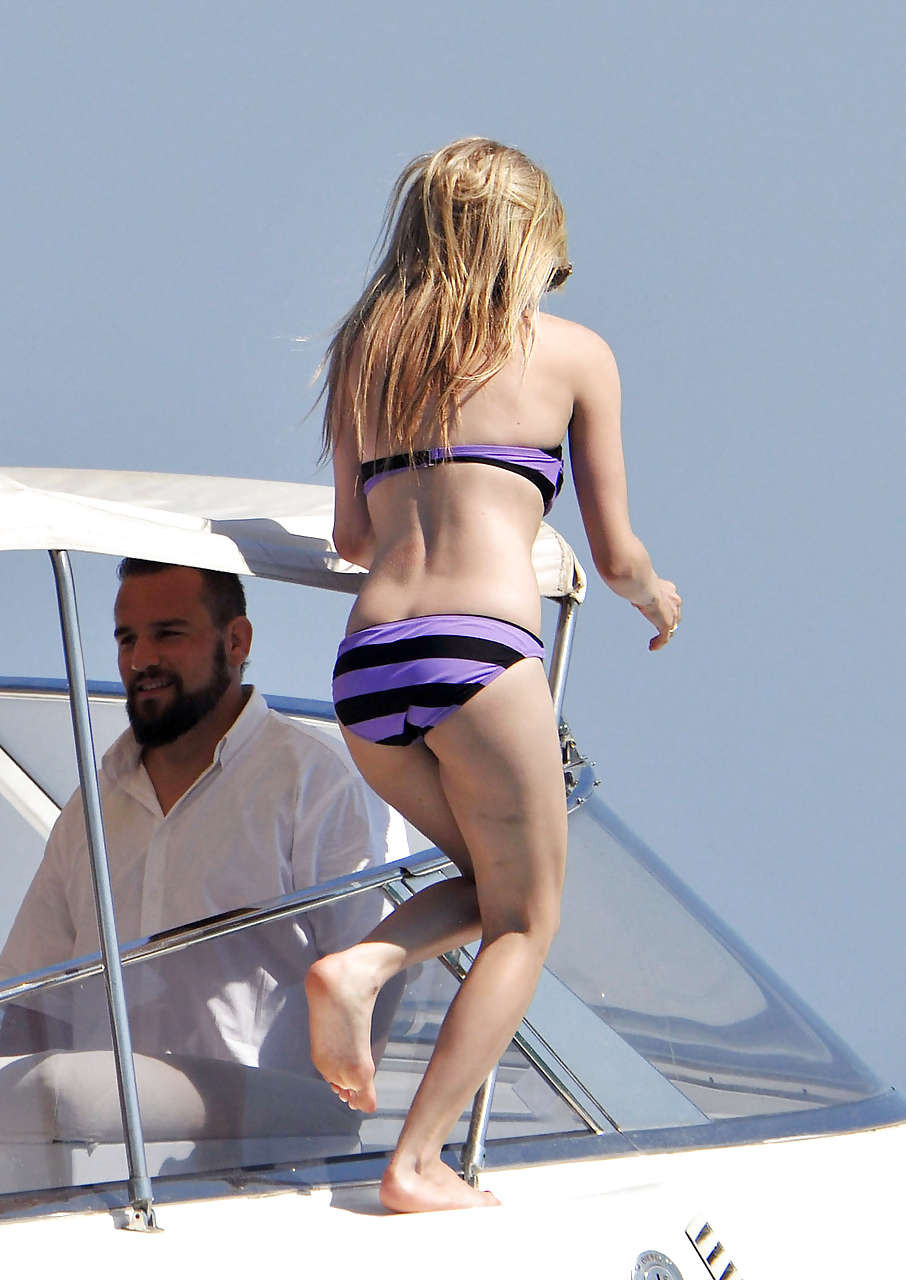 Avril Lavigne montrant une partie de son cul et son téton en bikini sur la plage.
 #75297397