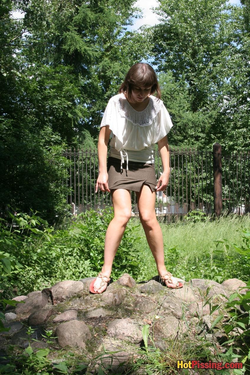 Linda chica en una mini falda marrón con un corte salpica en las piedras
 #76523555