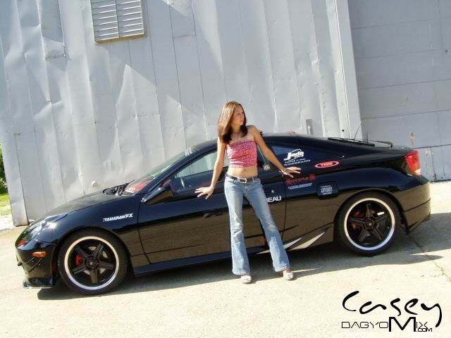 Joven asiática posando al aire libre con los coches
 #70012425
