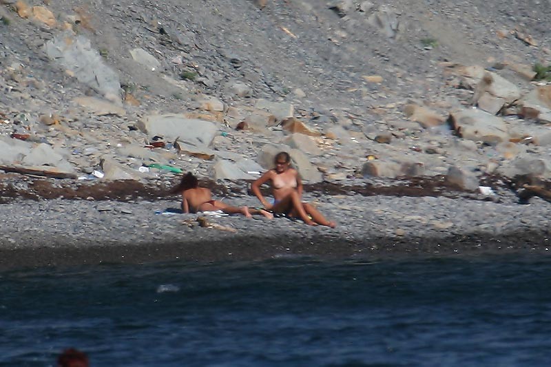 Une jeune femme à la poitrine généreuse exhibe son corps nu sur la plage.
 #72253169