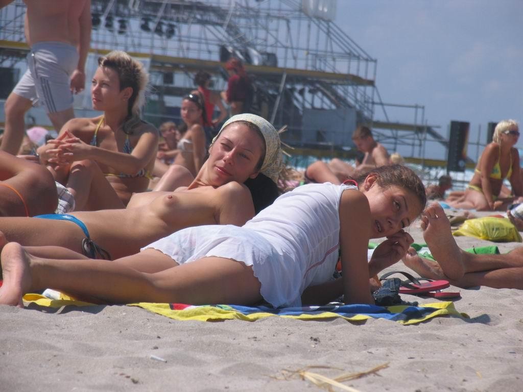 Une jeune femme à la poitrine généreuse exhibe son corps nu sur la plage.
 #72253234