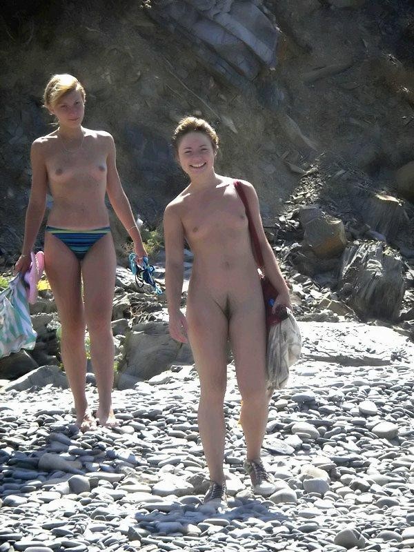Une jeune femme à la poitrine généreuse exhibe son corps nu sur la plage.
 #72253267