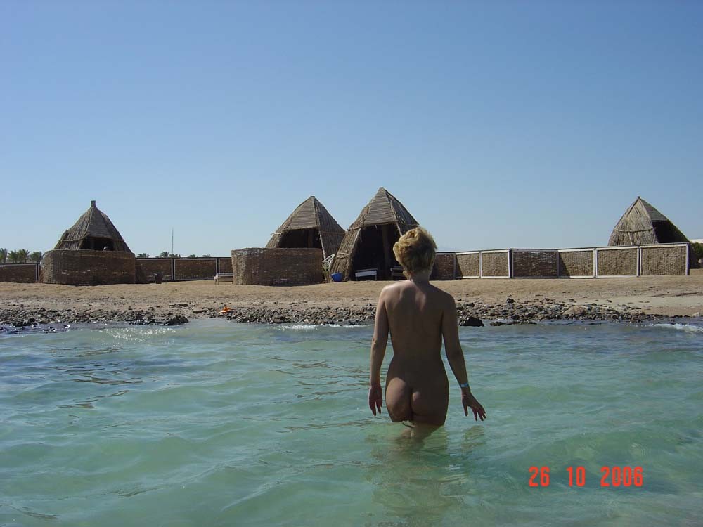 Une jeune femme à la poitrine généreuse exhibe son corps nu sur la plage.
 #72253276