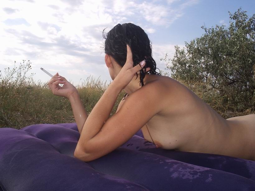 Une jeune femme à la poitrine généreuse exhibe son corps nu sur la plage.
 #72253283