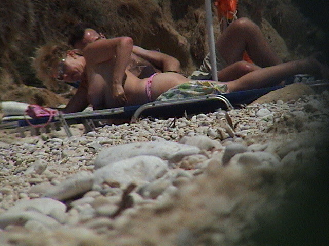 Une jeune femme à la poitrine généreuse exhibe son corps nu sur la plage.
 #72253308