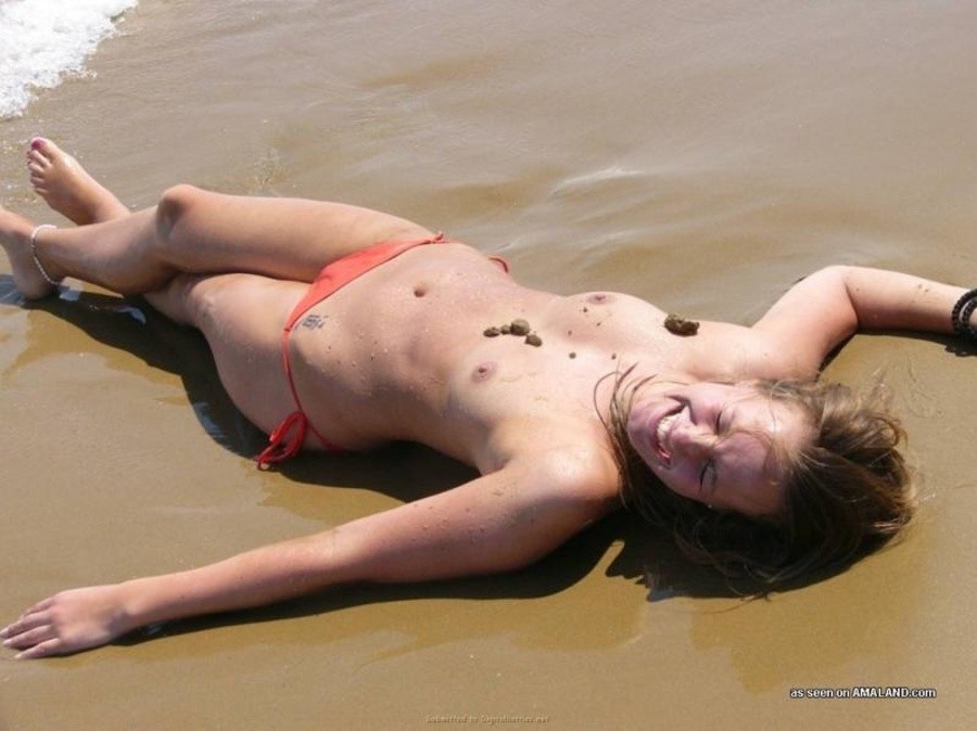 Une jeune blonde s'amusant les seins nus à la plage.
 #67627375
