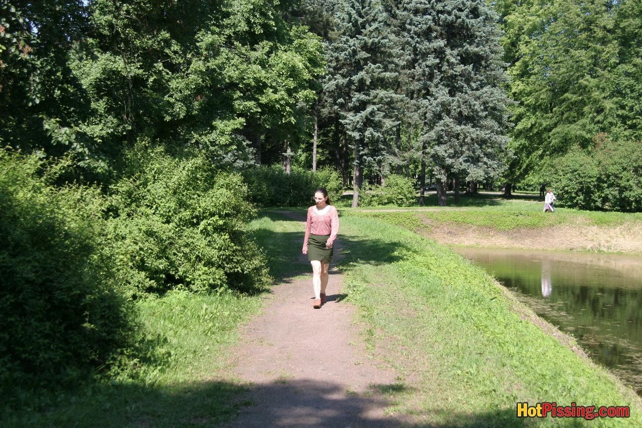 眼鏡をかけたキュートな女の子が、公園での散歩を中断して慎重におしっこをする
 #76523803