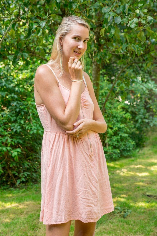 Sofie zieht langsam den Reißverschluss ihres Kleides herunter
 #78589838