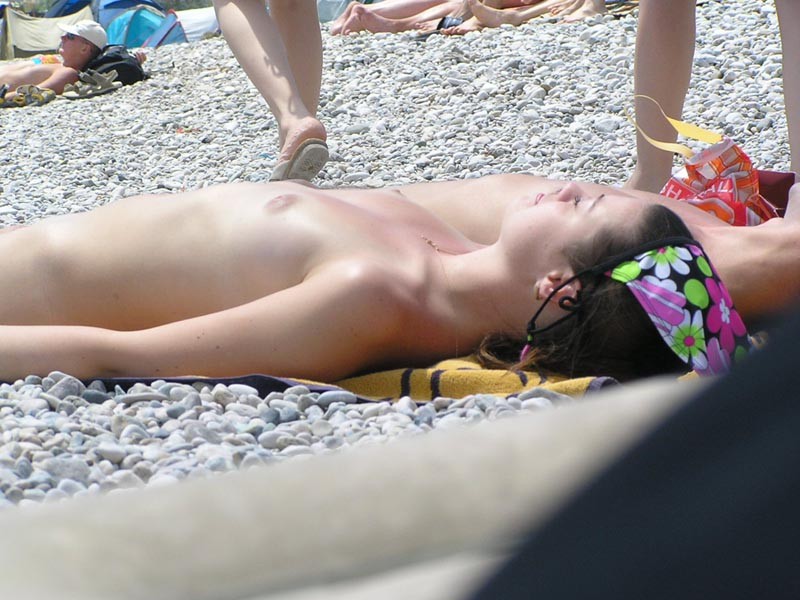 Amigos jóvenes desnudos juegan en una playa pública
 #72250332