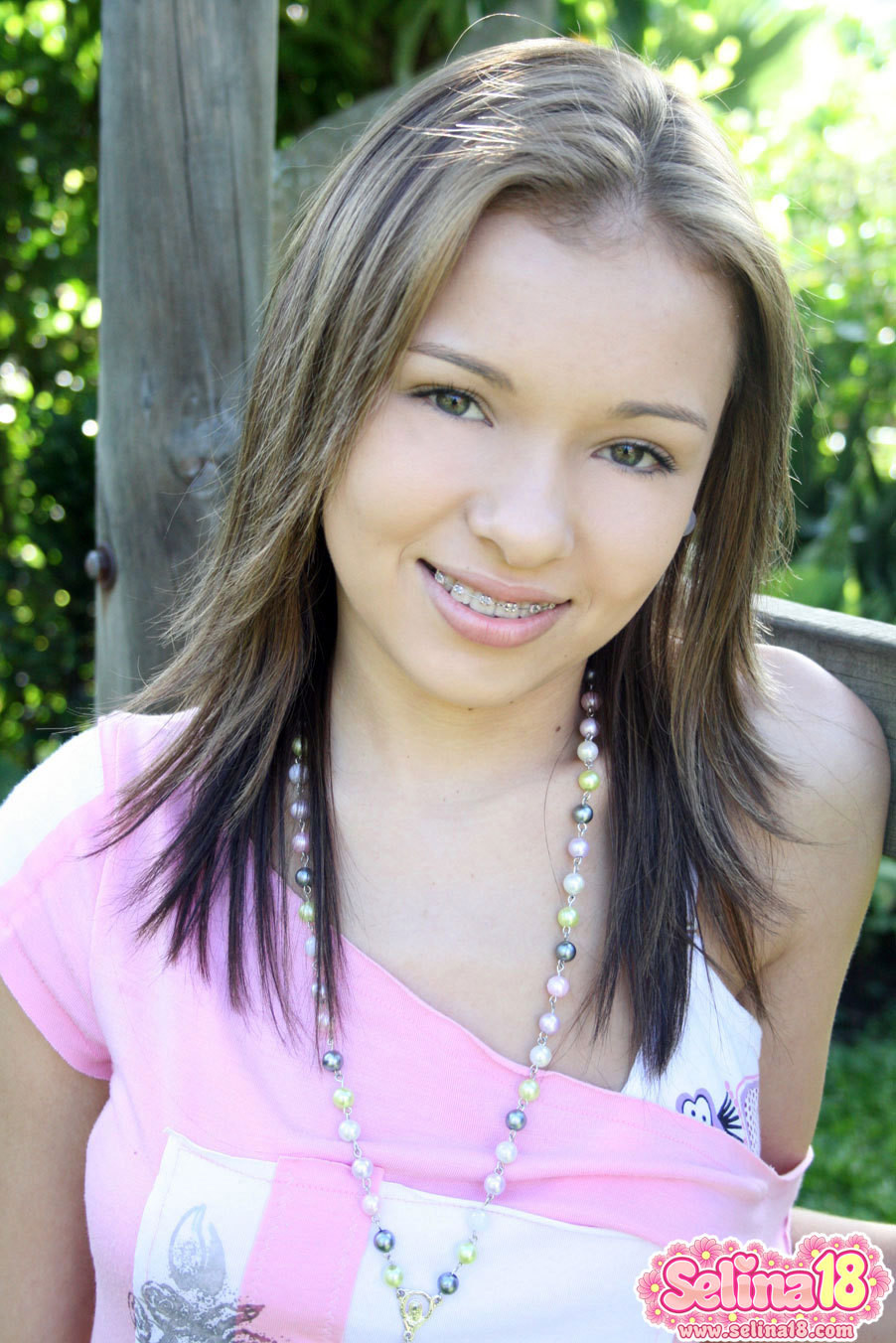 Adorable joven con brackets al aire libre en un columpio
 #79025670