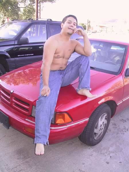 Amature guy posing by his red car #77009747