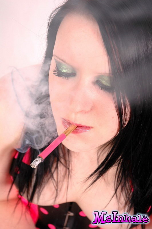 Giovane bruna che fuma una sigaretta rosa
 #74981236