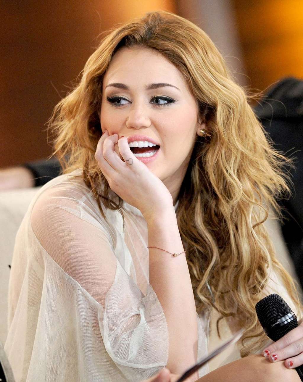 Miley Cyrus dans une robe transparente exposant sa culotte et ses jambes écartées.
 #75327191