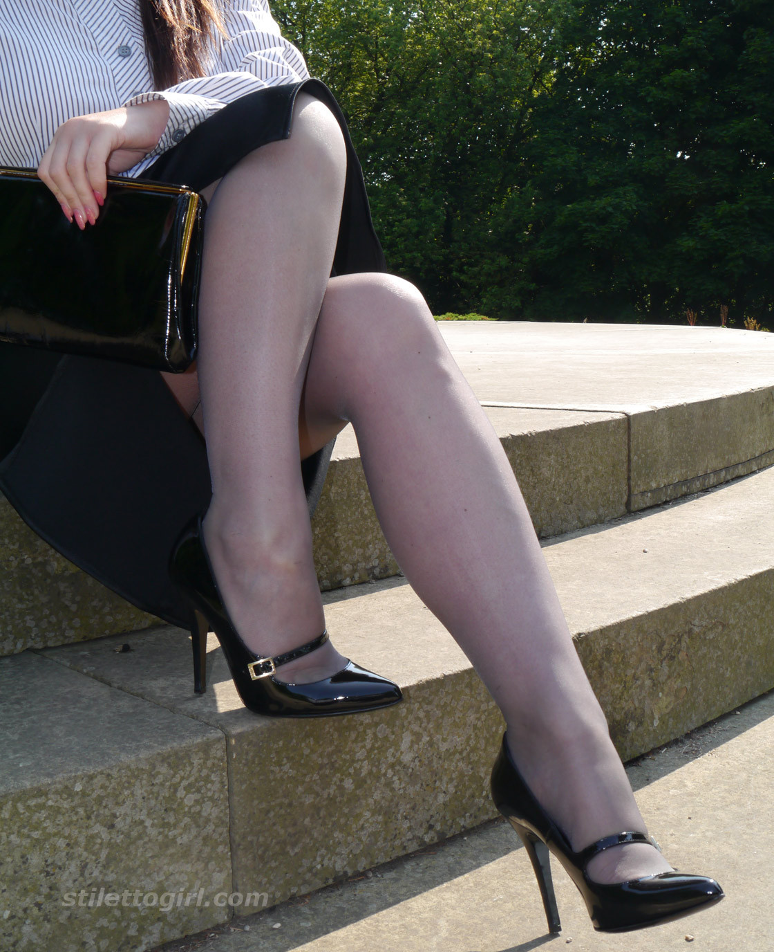 Une jeune femme de bureau très sexy pose à l'extérieur dans une paire de bas en nylon soyeux et de superbes bas.
 #72543512
