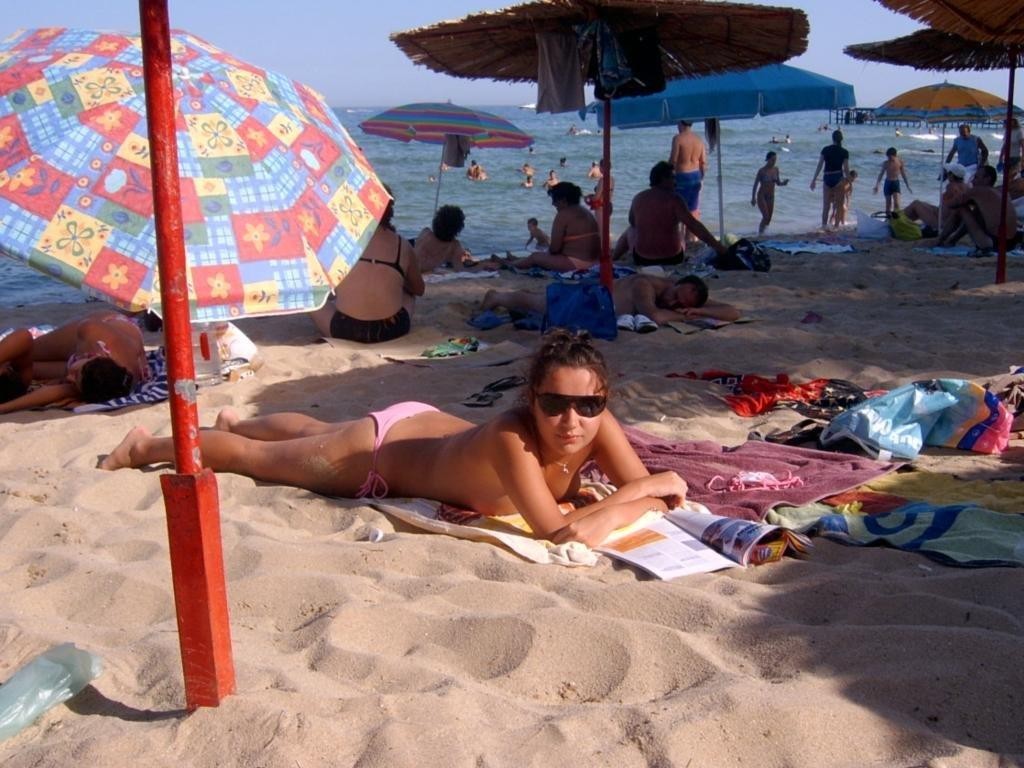 Une jeune nudiste mince se déshabille pour faire bronzer son corps nu.
 #72253390