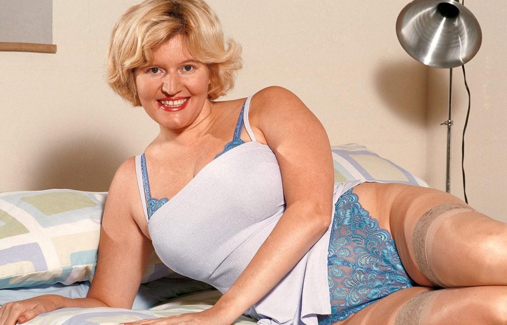 Busty blonde milf in bed strip teasing in sexy stockings #78521981