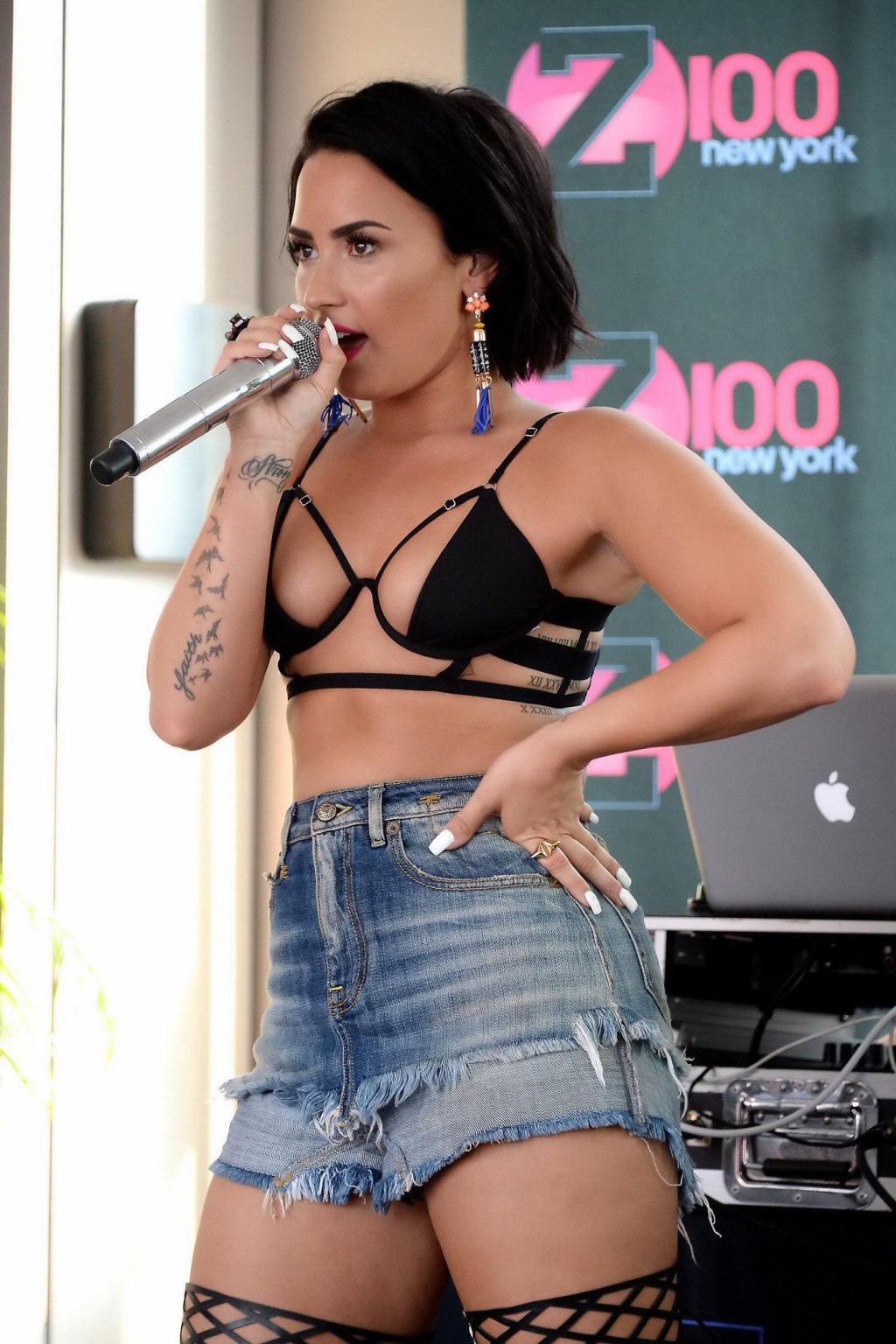 Demi Lovato busty in tiny black bikini top cutoffs and fishnets