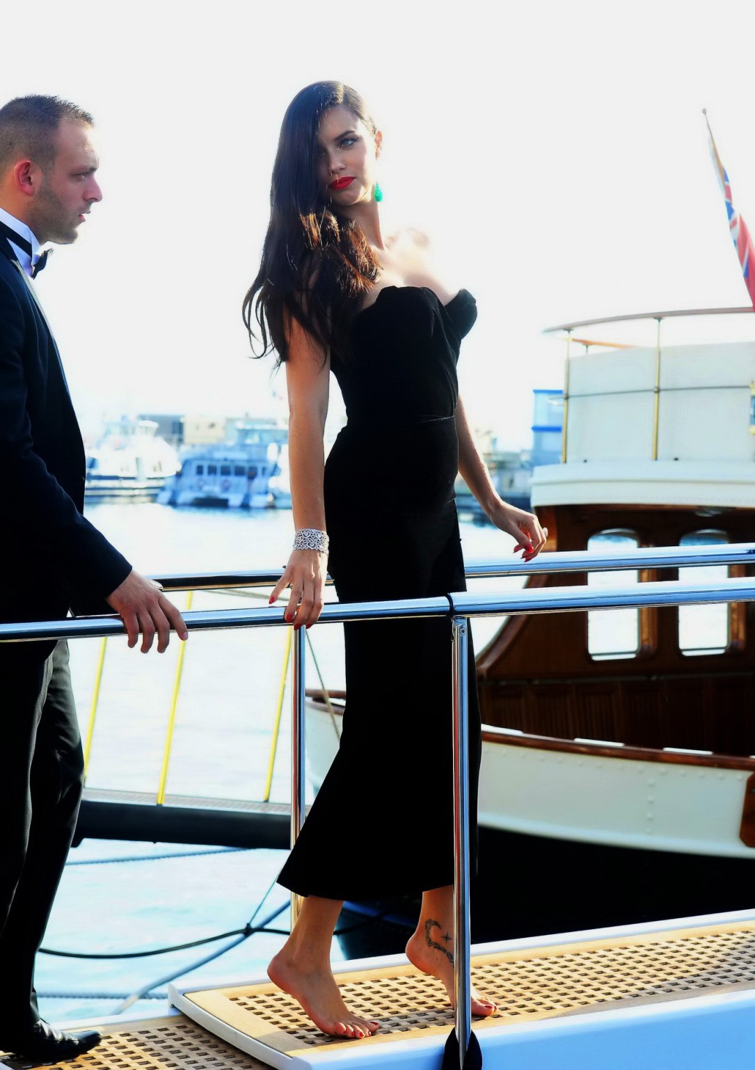 Adriana lima vollbusig in schwarzem trägerlosen Kleid beim Boarding auf einer Yacht in cannes
 #75163548