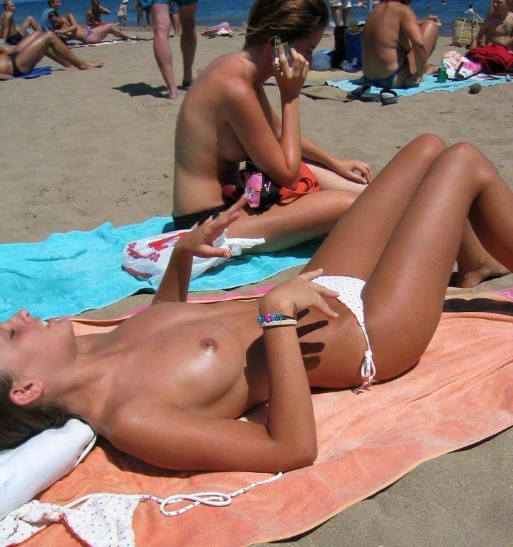 Giovani sexy e nude giocano insieme in una spiaggia pubblica
 #72243803