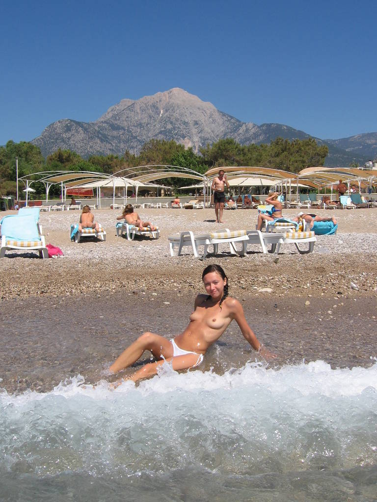 Deux amies jeunes nudistes s'amusent sur la plage.
 #72248050