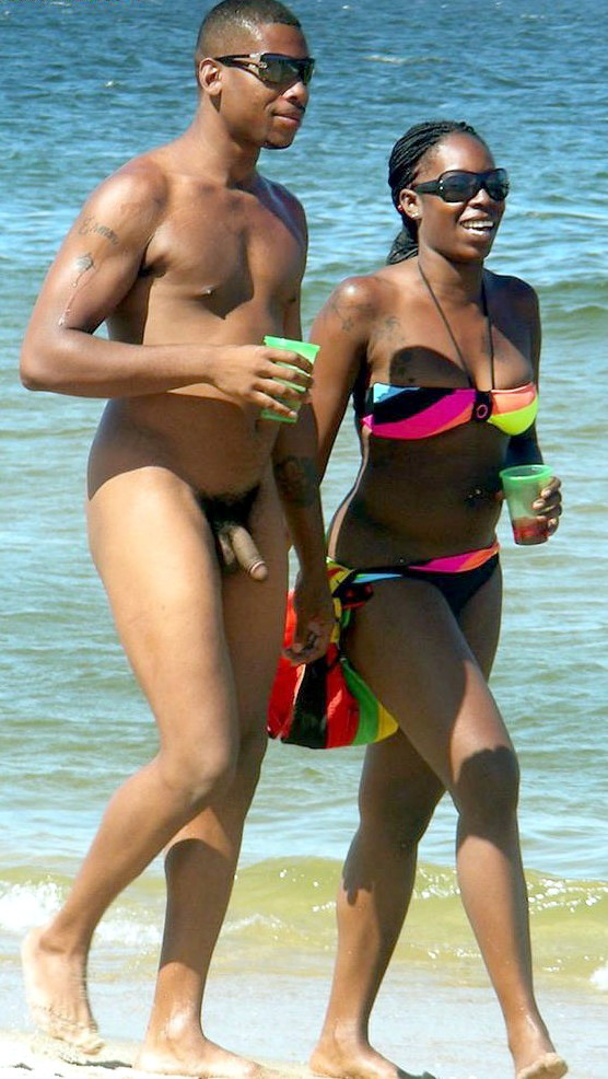 Nudista bionda si spoglia nuda in una spiaggia pubblica
 #72244011