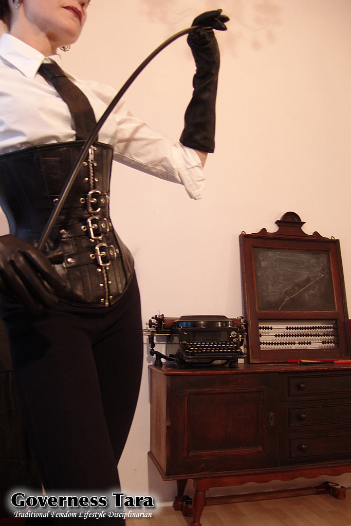 Domina tordue et corsetée pose dans des bottes en cuir à talons aiguilles.
 #72184555